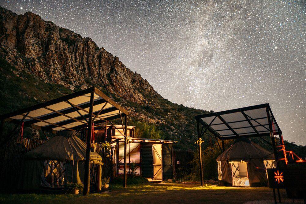 Malachite Yurt view of the exterior of the site at night with lights and mountain views