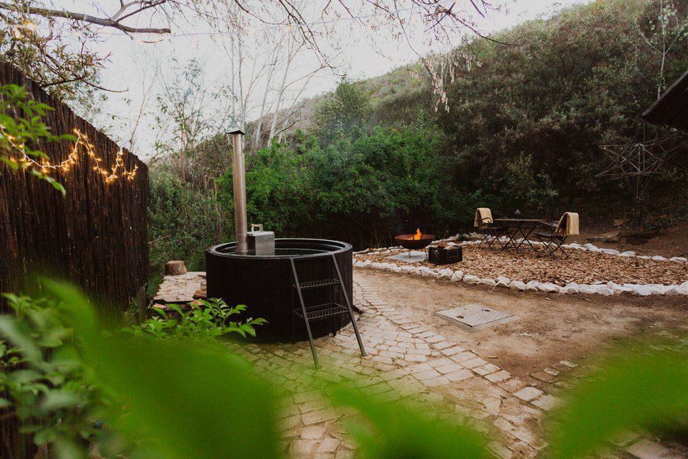 River Cabin view of the garden area with hot tub and green grass