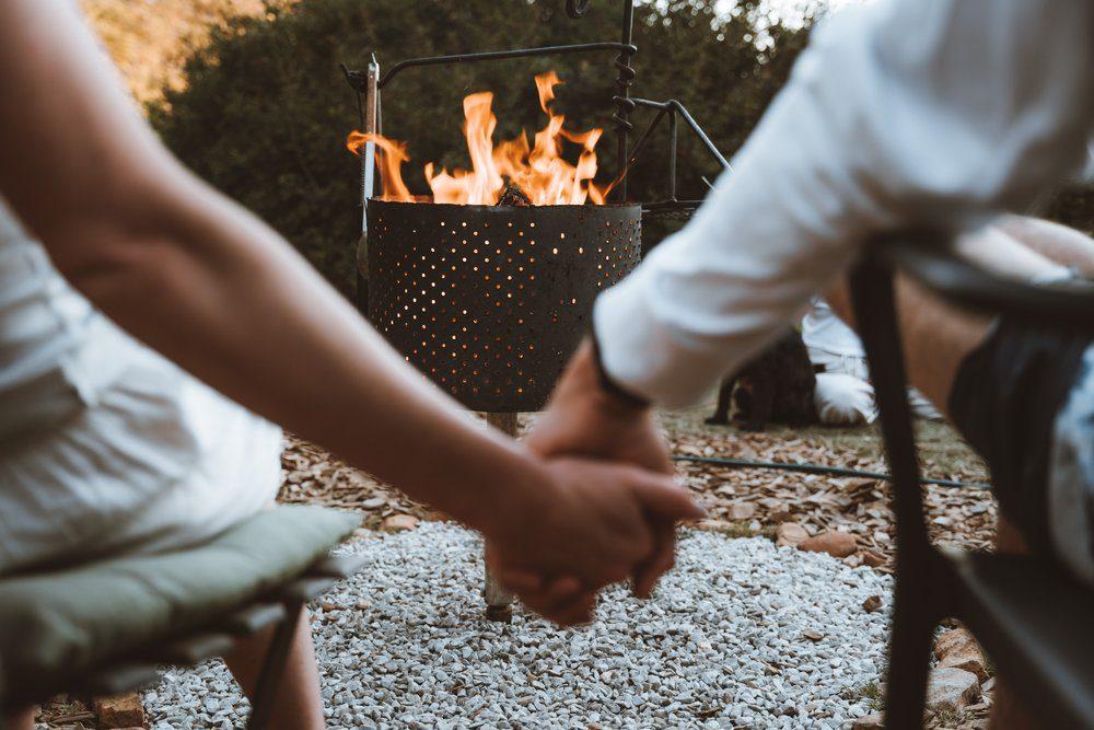 Kestrel Yurt view of couple holding hands in front of the fire