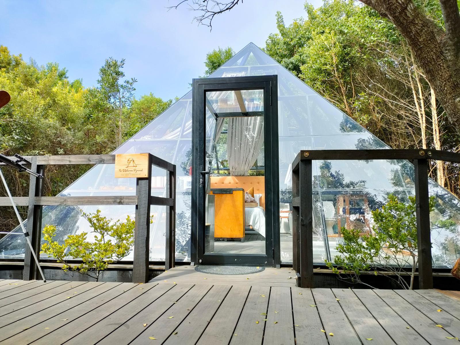 The Pyramid at Misty Mountain Reserve: Couple in robes on deck before glass pyramid in forest