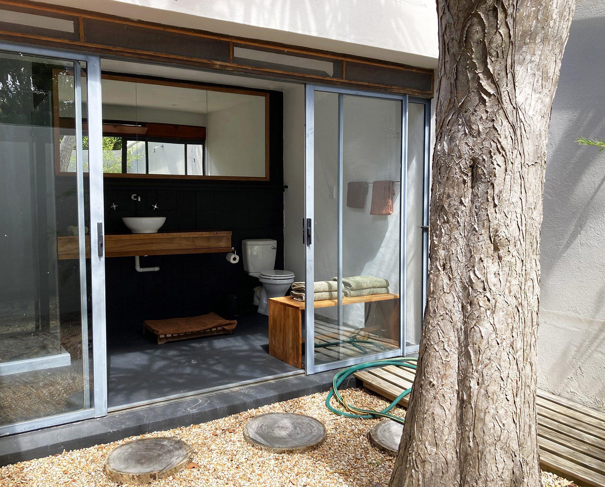 House on 215 view of the exterior of the patio area and tree truck