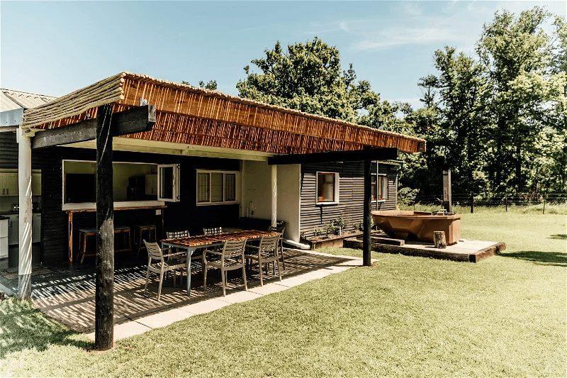 Blombos Cottage at Bokrivier: Covered patio dining table, copper hot tub, trees, blue sky