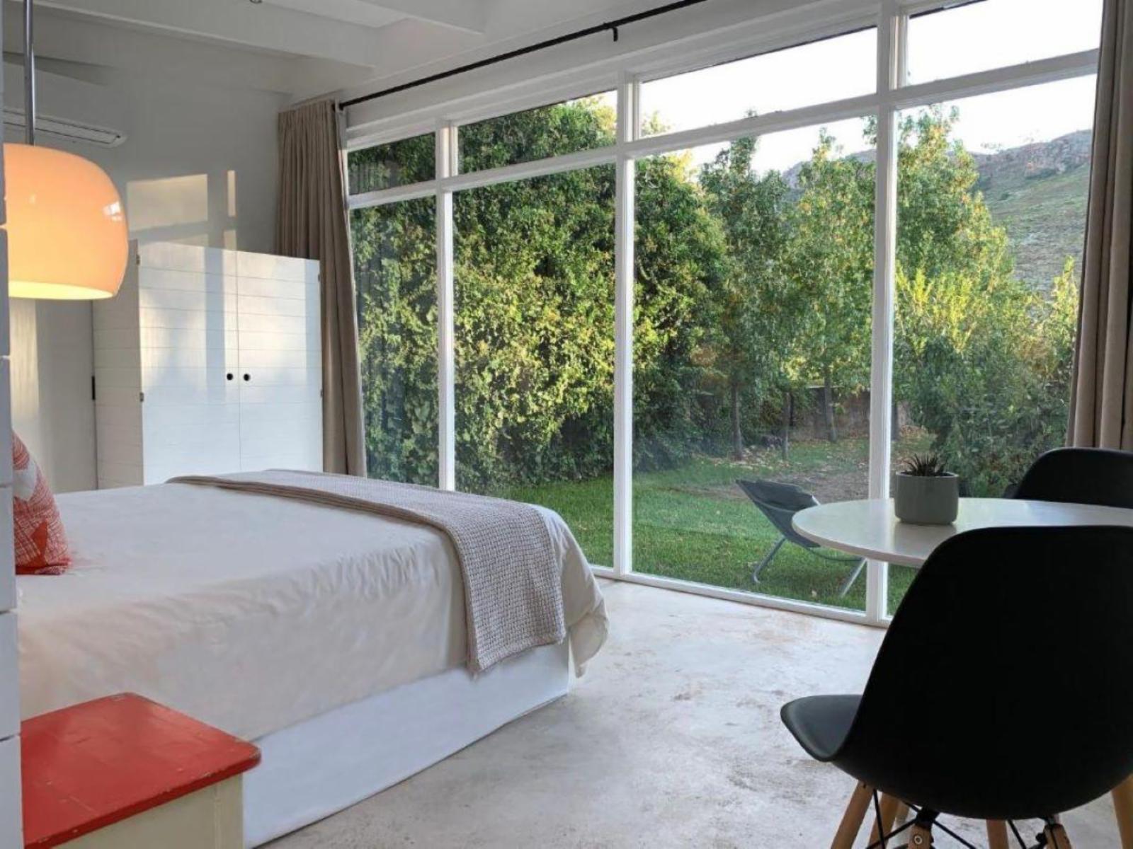 Gite Studio Franschhoek: Wood-fired hot tub on deck against orchard and mountain backdrop