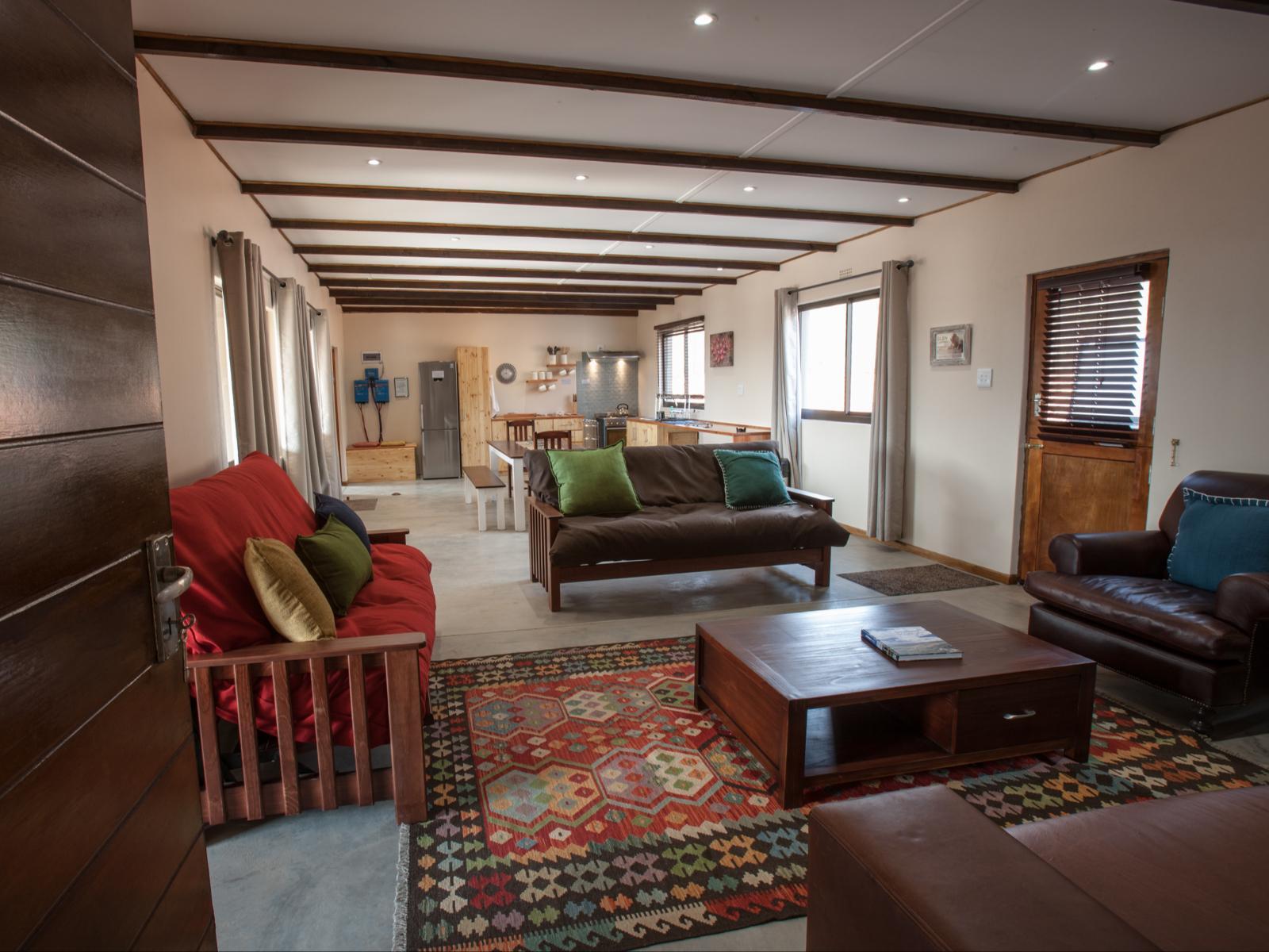 Southern Nights: Sweeping Karoo sunset deck, fire glowing, guests relaxing, sunken tub