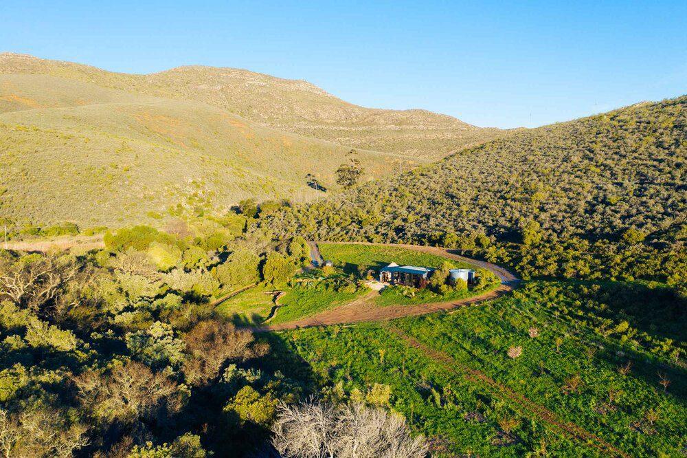 Forest View Yurt: Aerial of yurt nestled in lush green valley, golden light